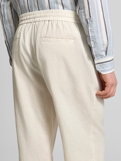 Männermodel trägt Relaxed Fit Hose mit elastischem Bund Modell 'ELLIOT' von Antony Morato in Off-White, Struktur durch Viskose-Leinen-Mix, Nahaufnahme Rückansicht.