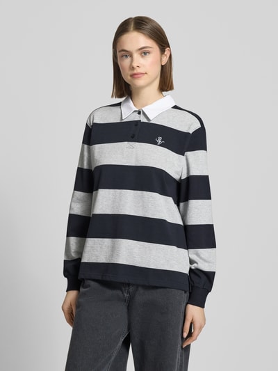 Frauenmodel trägt Polo-Langarmshirt mit Streifen und kontrastiger Knopfleiste von Review, reine Baumwolle, Regular Fit, gesticktes Logo, Ganzkörperansicht von vorne.