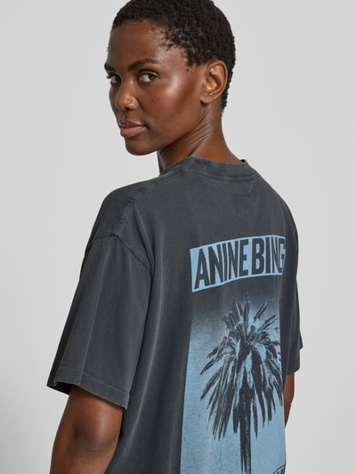 Frauenmodel trägt Oversized Fit T-Shirt mit Logo-Print von Anine Bing aus reiner Baumwolle in dunklem Ton, Rückenlänge 62 cm, Detailaufnahme Rückansicht.