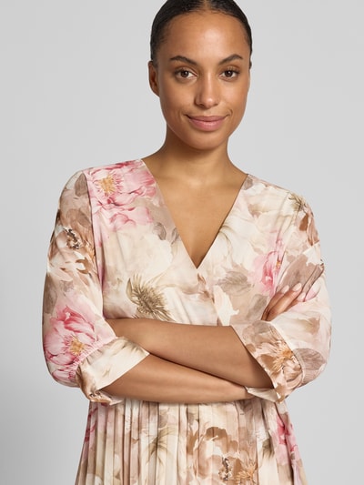Vrouwenmodel draagt Midikleid met floralem all-over print Model 'Matilda' van ZABAIONE, getailleerde pasvorm, v-hals, 1/2-mouwen, ruglengte maat S 121 cm, borstwijdte maat S 37 cm, mouwlengte maat S 44 cm, zachte beige en roze tinten, bloemenmotief, stof met lichte glans, Nahaufnahme Oberkörper