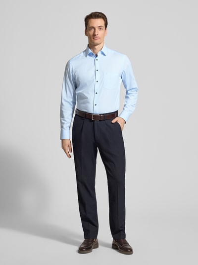 Męski model nosi Regular Fit Business-Hemd mit Kentkragen od OLYMP, jasnoniebieski, czysta bawełna, kieszeń na piersi z logo, długość tyłu w rozmiarze 40: 70 cm, szerokość ramion w rozmiarze 40: 45 cm, długość rękawa w rozmiarze 40: 65 cm, pełen widok z przodu.