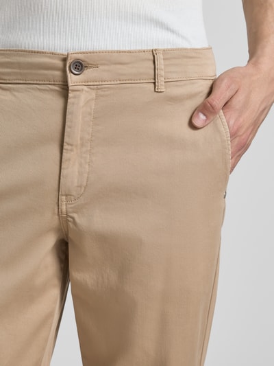 Mężczyznamodel nosi Straight Fit Chino mit Eingrifftaschen Modell 'Vance' von Jack & Jones, mieszanka bawełny, wpuszczane kieszenie, zapięcie na guzik i zamek błyskawiczny, szerokość w rozmiarze 32/32: 43 cm, długość wewnętrzna nogawki: 67 cm, jasnobeżowy, gładka tekstura, zbliżenie na górną część przodu