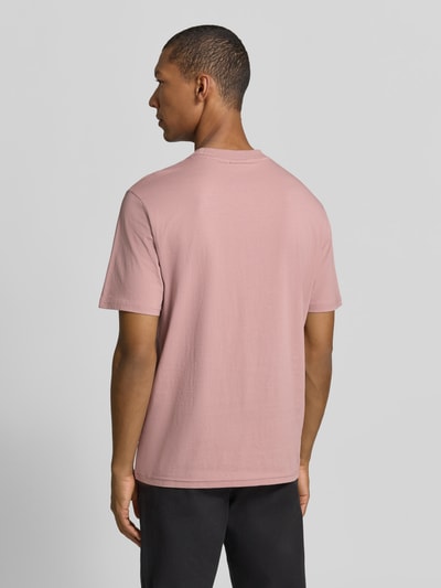 Męski model nosi T-Shirt mit Logo und Rundhalsausschnitt von Napapijri, mieszanka bawełny i elastanu, krój regular fit, długość tyłu w rozmiarze M: 63 cm, jasnoróżowy kolor, gładka tekstura, całkowity widok z tyłu.