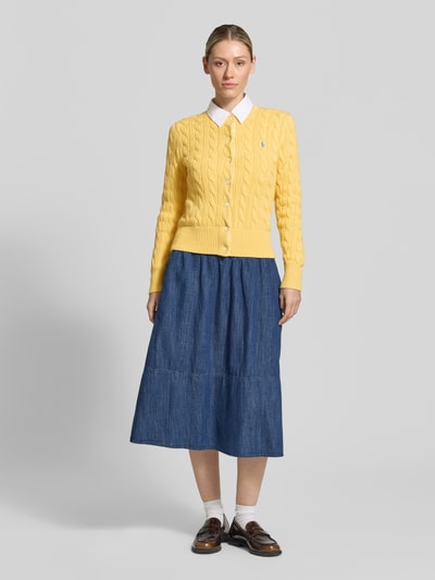 Frauenmodel trägt Regular Fit Strickjacke aus reiner Baumwolle von Polo Ralph Lauren, Optik: Unifarben, Strukturiert, Logo-Stitching, Zopfstrick, Rundhals, Langarm, gerippter Ärmelabschluss, Knopfleiste; Ganzkörperansicht von vorne.