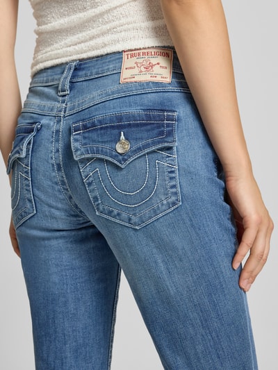 Kobieta nosi Bootcut-Jeans aus Baumwoll-Mix Modell 'BECCA' od TRUE RELIGION, jasnoniebieski denim, tekstura gładka, zbliżenie tylnej części ciała, damskie jeansy bootcut od TRUE RELIGION, kontekst: damskie bootcut jeansy od TRUE RELIGION.