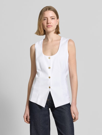 Frauenmodel trägt Slim Fit Weste aus Leinen-Mix von Tommy Hilfiger in Weiß, unifarben mit goldfarbenen Knöpfen, Nahaufnahme Oberkörper.