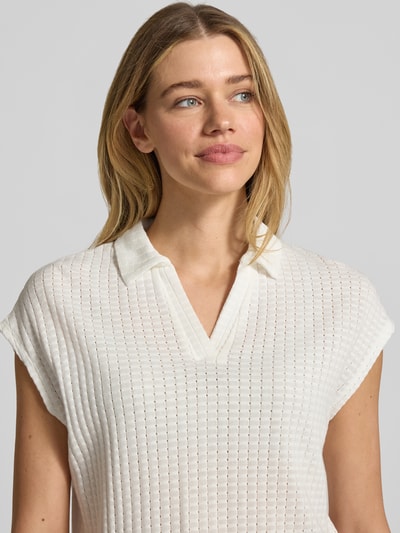 Frauenmodel trägt Regular Fit Poloshirt mit Strukturmuster Modell 'Kimena' von Someday aus Baumwoll-Mix, V-Ausschnitt, Nahaufnahme Oberkörper.
