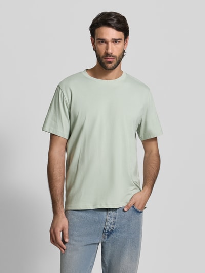 Męski model nosi Regular Fit T-Shirt aus reiner Baumwolle Modell 'ASPAN' von SELECTED HOMME, jasnozielony, gładki, krótki rękaw, okrągły dekolt, jersey, Ganzkörperansicht von vorne