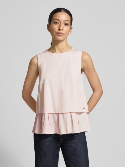 Modelka nosi Blusenshirt mit Volantsaum und Rundhalsausschnitt von Marc Cain, mieszanka bawełny i wiskozy, prosty krój, okrągły dekolt, dół obszyty falbaną, zamek błyskawiczny z tyłu, długość tyłu w rozmiarze 36: 59 cm, widok całej sylwetki z przodu.