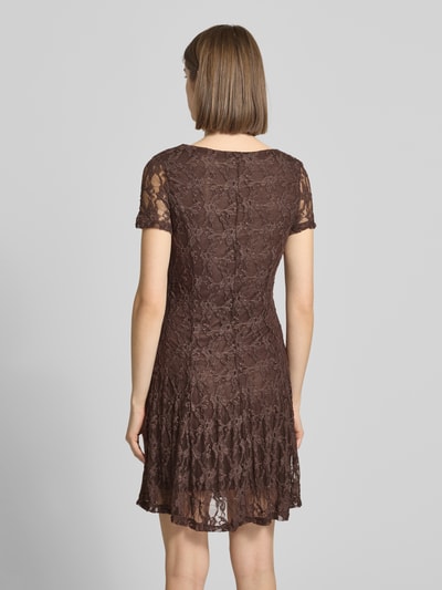 Frauenmodel trägt Slim Fit Minikleid aus Spitze Modell 'ALBINA' von Only in Braun mit Spitzenmuster, kurzarm, unifarben, Ganzkörperansicht Rückansicht.