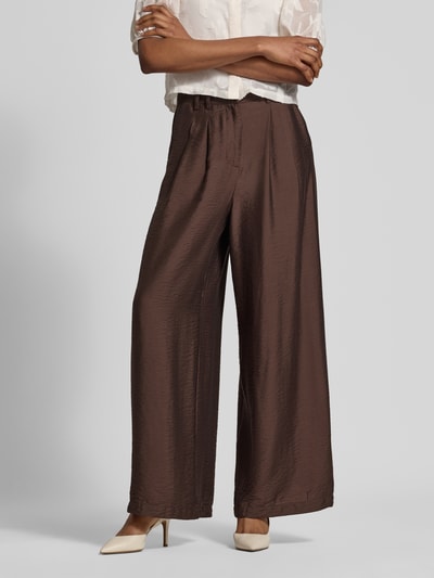 Frauenmodel trägt Wide Fit Hose aus Viskose-Mix Modell 'Finja' von GUIDO MARIA KRETSCHMER WOMAN, braun, Bundfalten, Ganzkörperansicht von vorne.