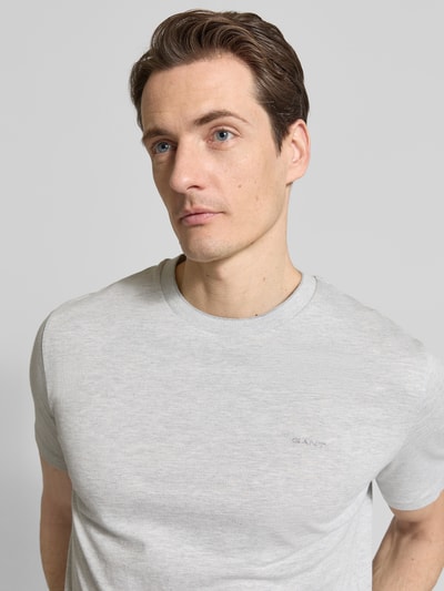 Männermodel trägt T-Shirt mit Rundhalsausschnitt und Label-Stitching von Gant, hellgrau, reine Baumwolle, Regular Fit, Nahaufnahme Oberkörper.
