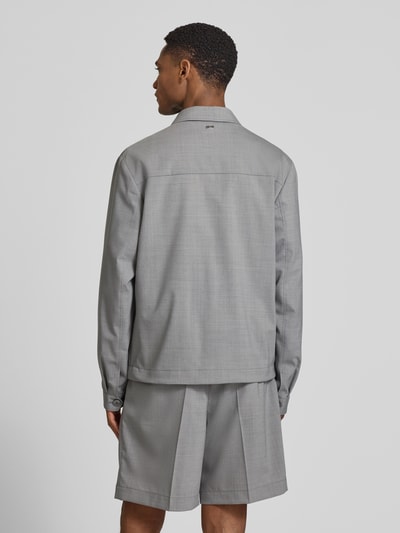 Männermodel trägt Regular Fit Hemdjacke aus Woll-Mix mit Kentkragen von bugatti, hellgrauer Stoff, glatte Textur, Ganzkörperansicht Rückansicht.
