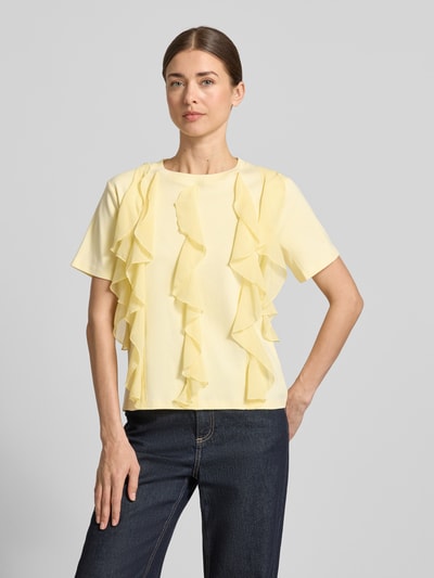 Vrouwenmodel draagt T-Shirt met Rüschen und Rundhalsausschnitt van Christian Berg Woman in lichtgeel, rechte fit, puur katoen, met ruches en ronde hals, ruglengte maat S 58 cm, vooraanzicht volledige lichaamsopname.