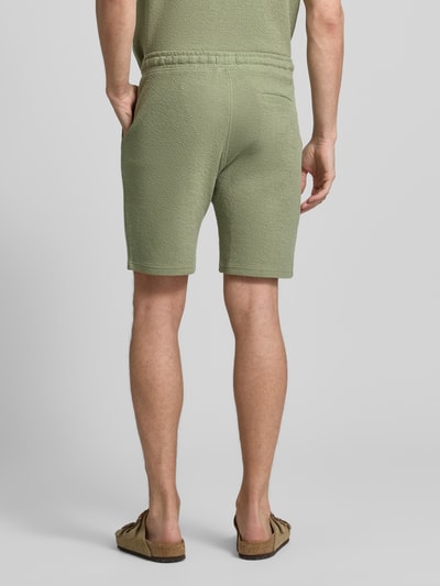 Männermodel trägt Sweatshorts mit elastischem Bund von MCNEAL, Strukturmuster, Gerade Passform, Eingriff- und Gesäßtaschen, Ganzkörperansicht Rückansicht.
