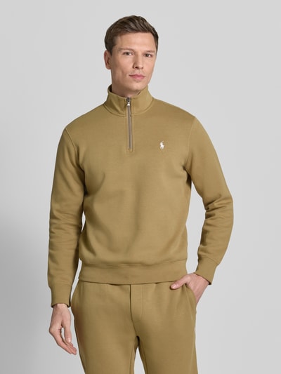 Męski model nosi Regular Fit Sweatshirt aus Baumwoll-Mix od Polo Ralph Lauren, jednolity kolor, krój regular fit, wyhaftowane logo, kołnierz troyer, długi rękaw, mieszanka bawełny, całkowity widok z przodu.