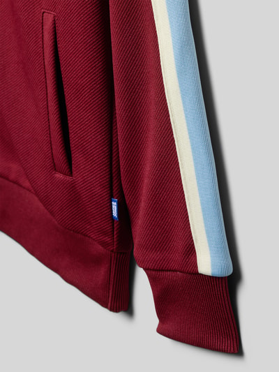 Produktfoto, Sweatjacke mit Eingrifftaschen Modell 'COTEDAZUR' von Jack & Jones, leinenowy mix, krój straight fit, czerwony kolor, niebiesko-kremowy pasek na rękawie, faktura prążkowana, detal z logo, dziecięca.