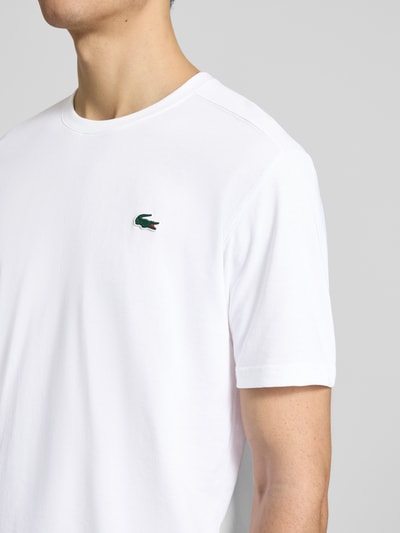 Mannenmodel draagt Regular Fit T-Shirt aus Baumwoll-Mix van Lacoste Sport, wit, unicolor, logo-applicatie, rond hals, katoenmix, droogt snel, detailopname bovenlichaam.