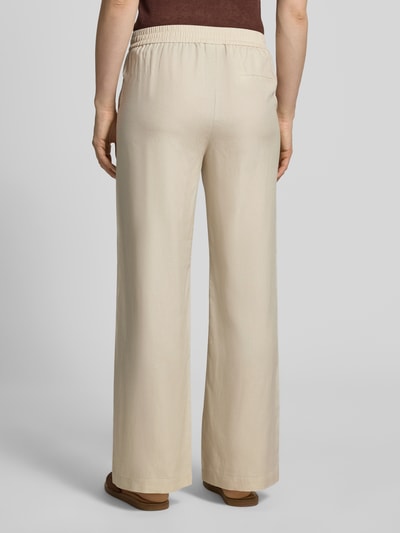Frauenmodel trägt Stoffhose aus Lyocell-Mix mit elastischem Bund von Comma, Relaxed-Fit, Gesäßtasche, beige, Ganzkörperansicht Rückansicht. Bundweite bei Größe 36/32: 39 cm, Innenbeinlänge: 78 cm, Lyocell-Mix mit Leinen-Anteil, Damen.
