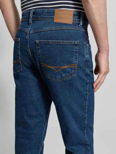 Męski model nosi Regular Fit Jeans im Used-Look od Christian Berg Men, bawełniany miks z dodatkiem stretchu, kieszenie, niebieski denim, szerokość w rozmiarze 32/32: 43 cm, długość nogawki wewnętrznej w rozmiarze 32/32: 83 cm, detailaufnahme tyłu.