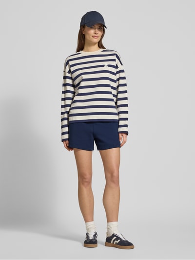Kobiece modelka nosi Regular Fit Sweatshorts aus reiner Baumwolle von Lacoste, efekt: jednolity kolor, krój regular fit, wyhaftowane logo, tunel, ściągacz: elastyczny, wpuszczane kieszenie, materiał: bawełna; całkowity widok z przodu.