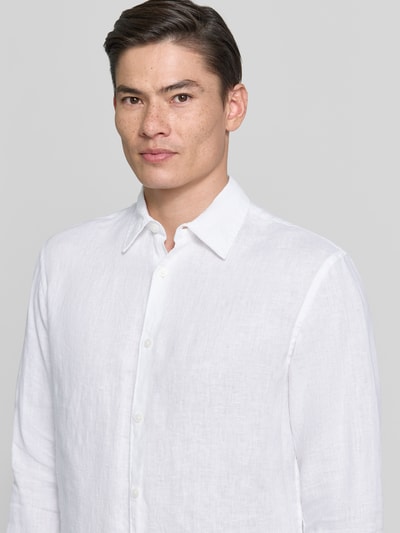 Männermodel trägt Regular Fit Leinenhemd aus reinen Leinen Modell 'Lawrence' von Jack & Jones Premium in Weiß, Nahaufnahme Oberkörper. Reine Leinen, Kentkragen, Langärmelig, durchgehende Knopfleiste. Rückenlänge 74 cm, Schulterbreite 45 cm, Ärmellänge 66 cm bei Größe M.