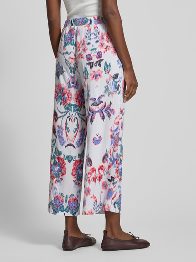 Frauenmodel trägt Culotte aus Viskose mit elastischem Bund von Christian Berg Woman, Blumenmuster in Rot und Blau, Ganzkörperansicht Rückansicht.