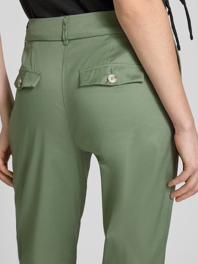Frauenmodel trägt Slim Fit Stoffhose in verkürzter Passform von Christian Berg Woman in Grün, Baumwoll-Mix, Gesäßtaschen, Detailaufnahme Rückansicht.