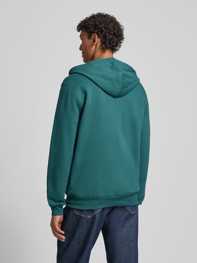 Männermodel trägt Sweatjacke mit Logo und Känguru-Tasche von GAP in Petrol, Baumwoll-Mix, Regular Fit, Ganzkörperansicht Rückansicht.