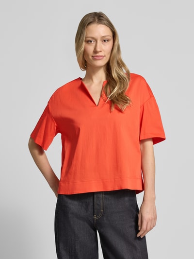 Frauenmodel trägt Relaxed Fit T-Shirt mit Tunika-Ausschnitt von Milano Italy aus elastischem Baumwoll-Mix in leuchtendem Orange, Kurzärmelig, Ganzkörperansicht von vorne.