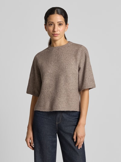 Kobieta modelka nosi sweter oversized z dodatkiem wełny model 'BOOM' od VERO MODA, beżowy, prosta faktura, widok z przodu, ujęcie całej sylwetki.