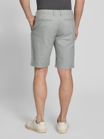 Männermodel trägt Regular Fit Chinoshorts aus Baumwoll-Mix Modell 'PHOENIX' von s.Oliver RED LABEL, Bi-Color Optik, Bundabschluss elastisch, 5-Pocket-Design, Ganzkörperansicht Rückansicht.