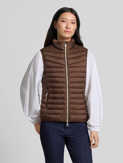 Vrouwenmodel draagt bodywarmer in stiksels van FUCHS SCHMITT, getailleerd, opstaande kraag, tweewegritssluiting, kleur bruin, Ruglengte maat 36: 55 cm, Schouderbreedte maat 36: 39 cm, Borstwijdte maat 36: 48 cm, Ganzichaamsaanzicht van voren.