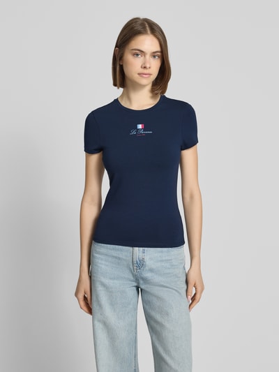 Frauenmodel trägt Slim Fit T-Shirt mit Rundhalsausschnitt und Frankreich-Motiv von REVIEW, dunkelblau, glatte Baumwoll-Mix-Textur, Ganzkörperansicht von vorne.