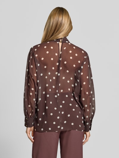 Vrouwenmodel draagt Relaxed Fit blouse in semi-transparant design van SWING, met sierstrik, met lange mouwen, ruglengte maat 36: 68 cm, geheelzicht achteraan.