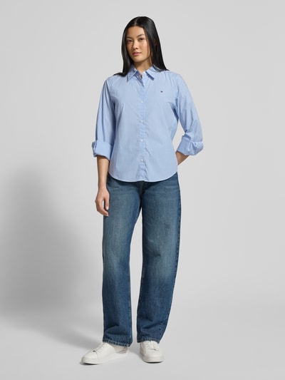 Frauenmodel trägt Regular Fit Hemdbluse aus Baumwoll-Mix von Tommy Hilfiger, Optik: Allover-Muster, Hemdkragen, Logo-Stitching, einreihige Knopfleiste, Langarm mit Manschette, abgerundeter Rumpfabschluss, Materialverarbeitung: Popeline, Ganzkörperansicht von vorne.
