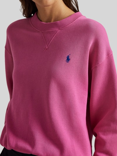 Kobiece modelka nosi Sweatshirt mit Label-Stitching od Polo Ralph Lauren w kolorze intensywnego różu, bawełniany miks, luźny krój, prążkowane wykończenia, okrągły dekolt, haftowane logo, zbliżenie na górną część ciała.