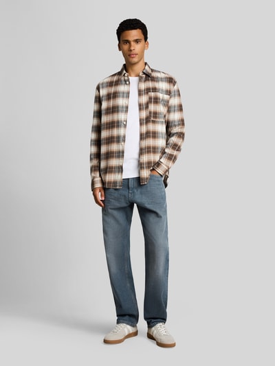 Männermodel trägt blaue Relaxed Fit Jeans aus reiner Baumwolle Modell 'TTWAYLEN' von Tom Tailor Denim, Herrenmode, Ganzkörperansicht von vorne.