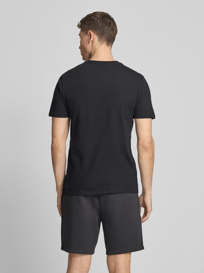 Männermodel trägt T-Shirt mit Logo und Rundhalsausschnitt von GAP in Schwarz, Reine Baumwolle, Regular-Fit, Rückenlänge 72 cm, Ganzkörperansicht Rückansicht.