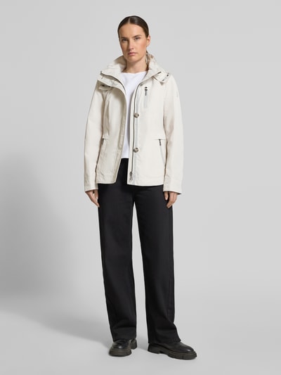 Vrouwenmodel draagt Jacke mit Kapuze und Eingrifftaschen van Gil Bret in regular fit, licht beige, met knoopsluiting, ritszakken, capuchon, weather protection, ruglengte maat 36: 67 cm, schouderbreedte: 40 cm, borstwijdte: 46 cm, mouwlengte: 64 cm, full body voorkant.