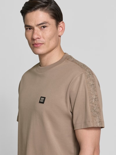 Männermodel trägt Relaxed Fit T-Shirt aus reiner Baumwolle Modell 'DROSTEE' von HUGO, Optik: Unifarben, Label-Patch, Rundhals, Kurzarm, Jersey, Nahaufnahme Oberkörper.