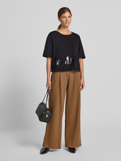Vrouwenmodel draagt zwart t-shirt met paillettenbesatz van Armani Exchange, puur katoen, los model, ronde hals, ruglengte maat S 45 cm, full body voorkant.