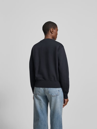Frauenmodel trägt Sweatshirt aus reiner Baumwolle von Anine Bing in Schwarz, lockere Passform, elastische Abschlüsse, Ganzkörperansicht Rückansicht.