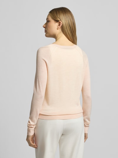 Frauenmodel trägt Regular Fit Strickjacke aus reiner Schurwolle Modell 'FONAMI' von BOSS in zartem Rosa, unifarben, Rückansicht.