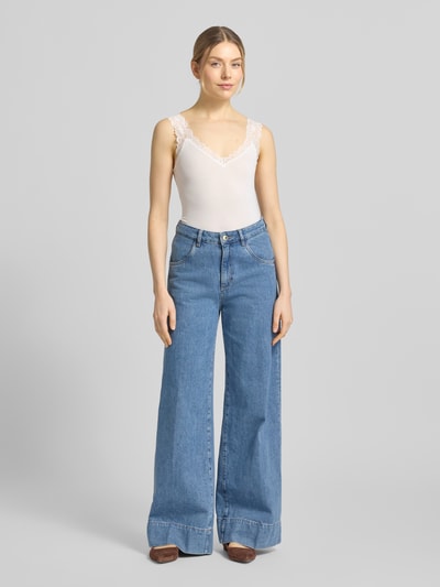 Frauenmodel trägt Slim Fit Tank Top aus Viskose-Mix Modell 'ROSA' von Vero Moda, Optik: Unifarben, Feinripp, Rüschen-Applikation, V-Ausschnitt, breite Träger, Ganzkörperansicht von vorne.