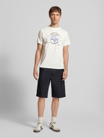 Męski model nosi Regular Fit T-Shirt mit Motiv-Print Modell 'Klements' von Blend z bawełny, okrągły dekolt, długość tyłu 65 cm, krój regular fit, nadruk z motywem, Ganzkörperansicht von vorne.