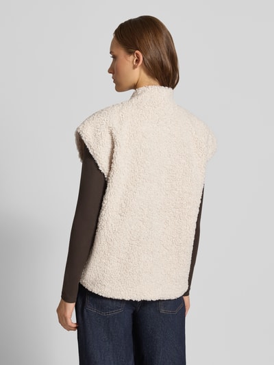 Modelka kobieca nosi kamizelkę Regular Fit w stylu imitacji futerka model 'NAYA' od ONLY, beżowa faktura, widok całej sylwetki od tyłu, kamizelka damska ONLY.