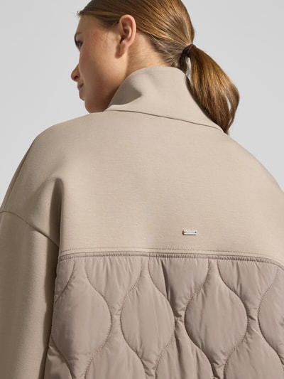 Frauenmodel trägt Jacke mit Steppnähten und Zweiwege-Reißverschluss von White Label aus beigem Baumwoll-Mix mit Stretch-Anteil, Regular Fit, Stehkragen, Textur mit glatten und gesteppten Flächen, Detailaufnahme Rückansicht.