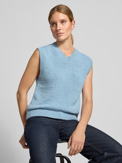 Frauenmodel trägt Regular Fit Pullunder aus reiner Baumwolle Modell 'ICONIC A' von ARMEDANGELS in Hellblau mit feiner Strickstruktur, Nahaufnahme Oberkörper. Damen Pullunder von ARMEDANGELS.