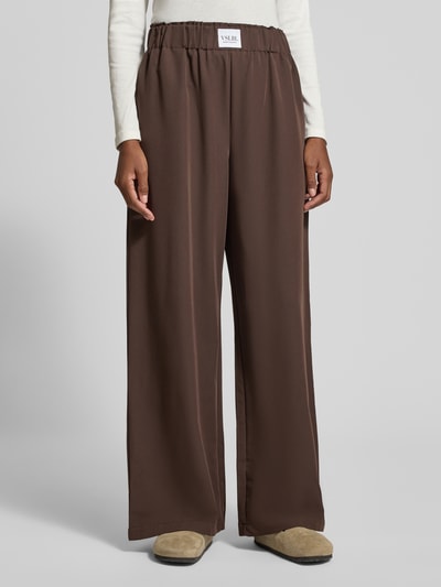 Frauenmodel trägt Wide Leg Hose aus Viskose-Mix Modell 'TOSCA' von VILLA SOPHIE, Optik: Unifarben, Passform: Wide Leg, Bundabschluss: Elastisch, seitliche Eingrifftaschen, Material: Viskose-Mix, in sattem Braunton mit glatter Textur, Ganzkörperansicht von vorne.
